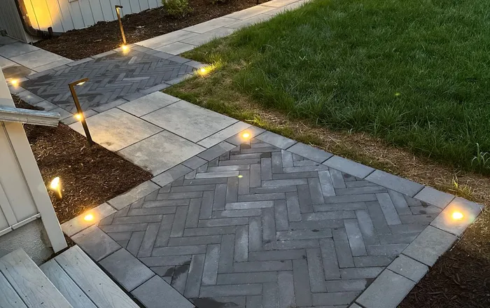 Herringbone paver front walk and steps lit at dusk after walkway repair at an Overlea, MD home