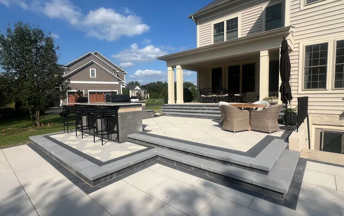 Multi-level paver patio with bluestone steps and a built-in bar, typical of hardscapes repaired in Overlea, MD