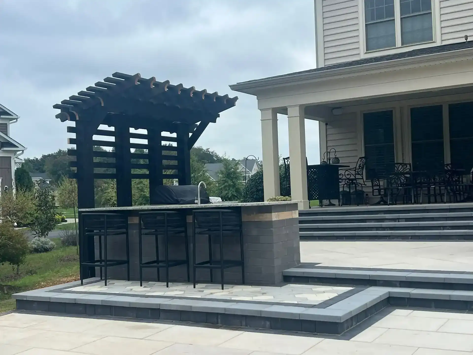 Outdoor bar black pergola paver patio